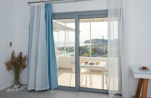 ProvatasSarantis Suites & Apartments的一间设有滑动玻璃门和桌子的房间