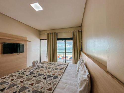 马拉戈日Pousada Villa的一间卧室设有一张床,享有海景