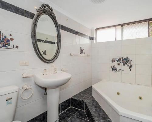 珀斯Queen Size Bedroom Near Sawn River的白色的浴室设有水槽、浴缸和镜子