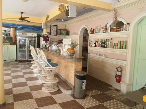 博卡奇卡Hotel Mango的厨房设有酒吧,地面铺有格子