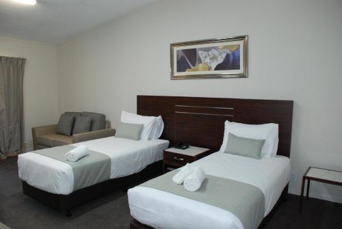 奥克兰VR度假酒店的酒店客房,配有两张床和椅子