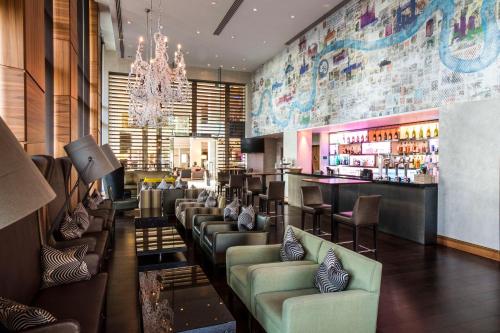 希灵登希尔顿伦敦希思罗机场5号航站楼酒店的餐厅设有带沙发的酒吧以及酒吧西德克斯(Sidx sidx)