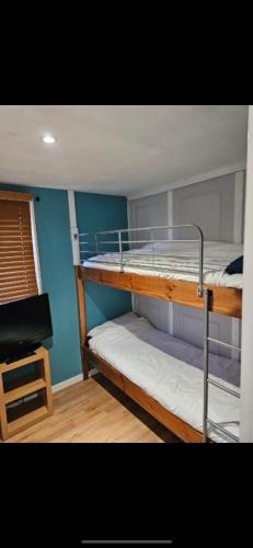 Kent2 Bedroom Chalet Isle of Sheppey Holiday Village的配有书桌的客房内的两张双层床