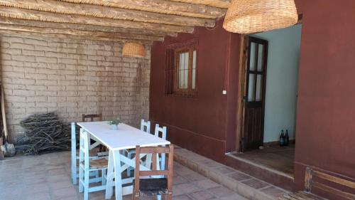 圣卡洛斯La casa Roja的一间有门的房间,一张白色的桌子和椅子