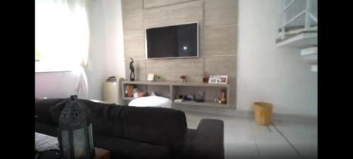 索罗卡巴Quarto Privativo em Casa Linda的带沙发和平面电视的客厅