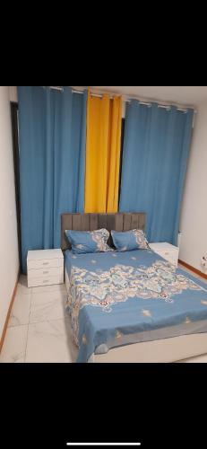 São TiagoPensão lopes的一间卧室配有蓝色和黄色窗帘的床