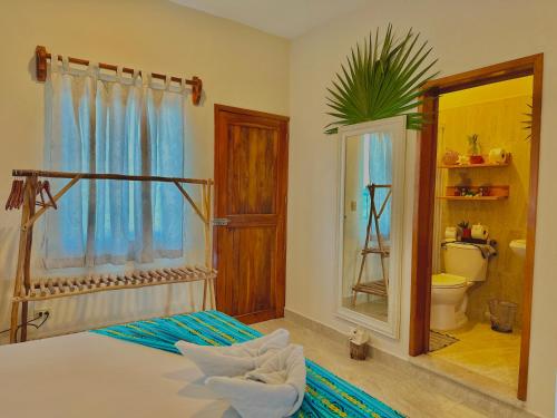 玛哈威Hotel Jaiba Mahahual - Adults Only的一间带一张床的卧室和一间带镜子的浴室