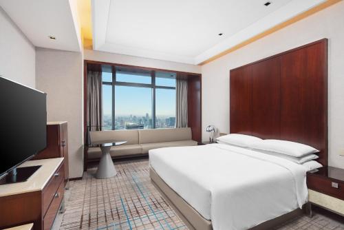 上海上海龙之梦万丽酒店的卧室配有一张白色大床和电视。