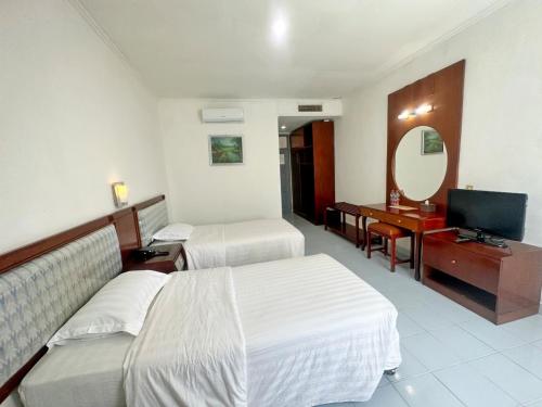 SibolgaHotel Wisata Indah Sibolga的酒店客房设有两张床和电视。