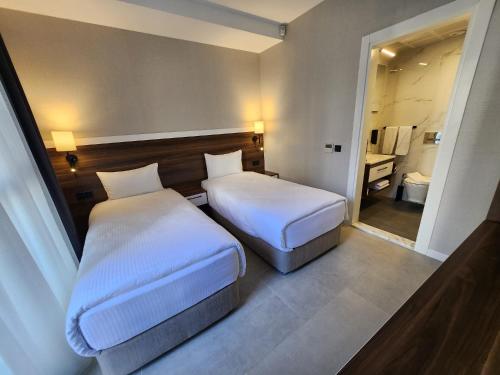 库萨达斯Lulubay Rooms & Suites的酒店客房带两张床和一间浴室