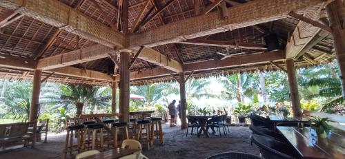 NauhangSulu Sunset Beach Resort的餐厅设有桌椅,背景人员