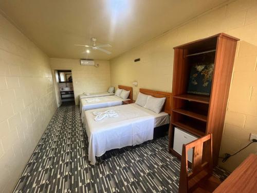 MulifanuaTransit Motel的一间设有两张床和书架的房间