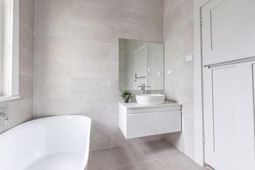 伊斯特伍德Homely 4 Bdrms House in Eastwood Sleeps 11的白色的浴室设有水槽和镜子