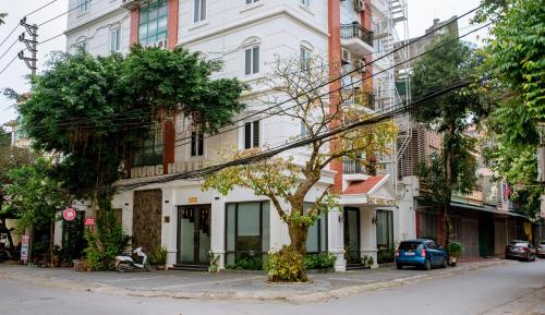 清化Bảo Hưng Hotel的建筑物前的街道上的树