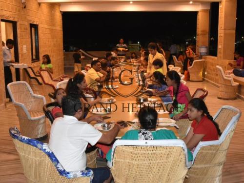 斋沙默尔Hotel Grand Heritage Jaisalmer的一群坐在桌子旁吃饭的人