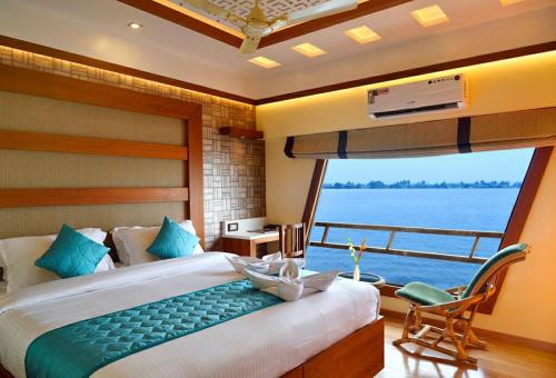 阿勒皮Luxury Houseboat的一间卧室设有一张大床和一个大窗户