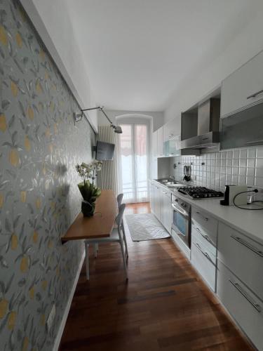 韦内雷港意大利假日度假屋的厨房配有白色橱柜和一张带花瓶的桌子