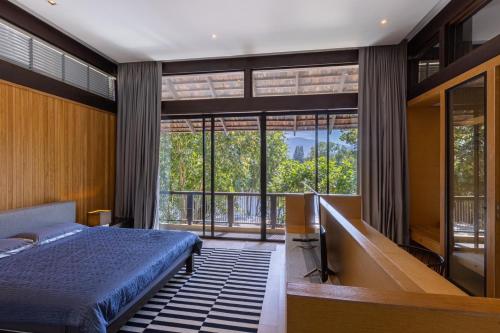 Ban Tha ChangKhaoyai Kirimaya Atta Residence 5 BR Villa的一间卧室设有一张床和一个大窗户