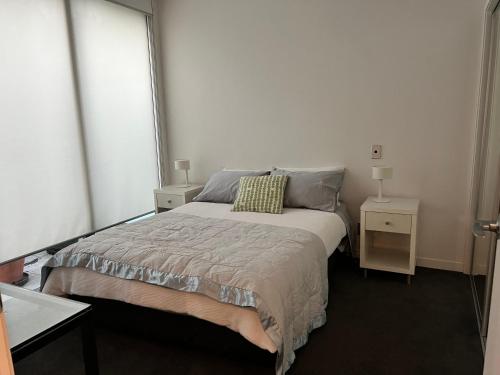 奥克兰Lovely 2 bedrm apartment in Auckland's viaduct的一间卧室配有一张带2个床头柜的大床