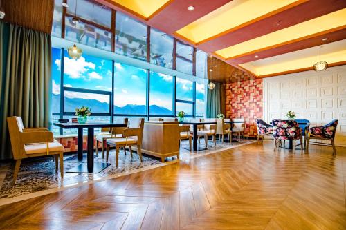 拉萨美豪酒店拉萨店的餐厅设有桌椅和大窗户。