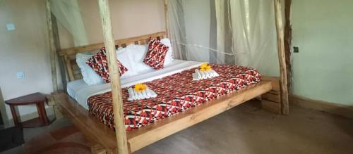 KinkiziBwindi My Home的一间卧室配有一张带枕头的木床