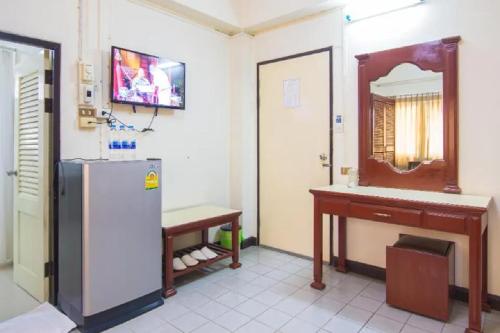 南邦Khelang Nakorn Hotel的厨房配有冰箱、桌子和镜子