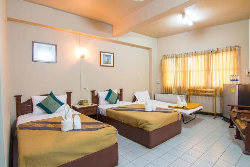 南邦Khelang Nakorn Hotel的一间酒店客房,房间内设有两张床