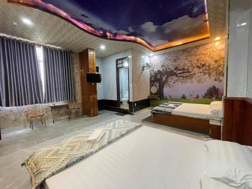 Ấp Phú ThọHoàng Gia Hotel - 1224 CMT8 Bình Dương - by Bay Luxury的一间卧室配有一张床,天花板上画着一幅画