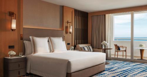 迪拜Jumeirah Beach Hotel Dubai的一间酒店客房,设有一张大床和一个大窗户