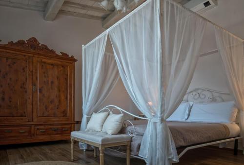 塔瓦尔努泽Casa Cantagalli的一间卧室配有一张天蓬床和椅子