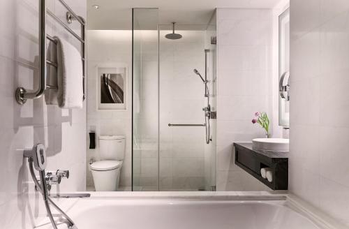 新加坡Carlton City Hotel Singapore的白色的浴室设有浴缸和卫生间。