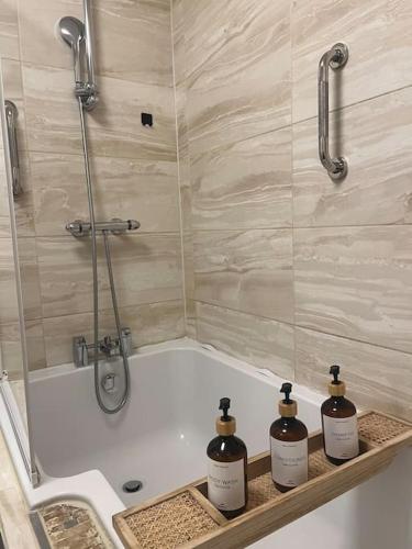 伯明翰Birminghams Finest的浴室配有浴缸及三瓶肥皂