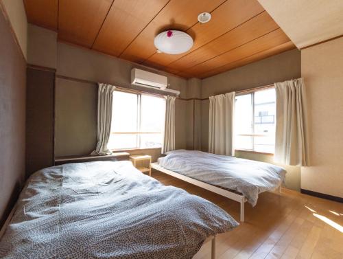 高松Hostel JAQ takamatsu的一间卧室设有两张床和窗户。