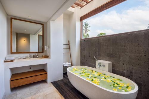 乌布Dinara Ubud的带浴缸、水槽和镜子的浴室