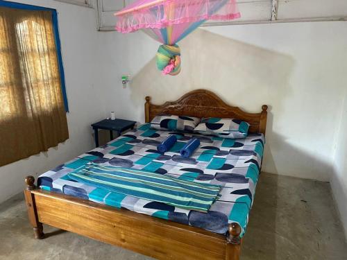卡尔皮蒂耶araliya villa的一间卧室配有一张带五颜六色棉被的木床