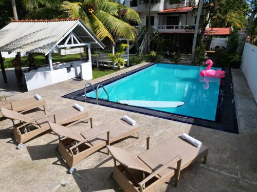 哈巴拉杜瓦Dream Villa with Pool的一个带躺椅的游泳池和一个游泳池