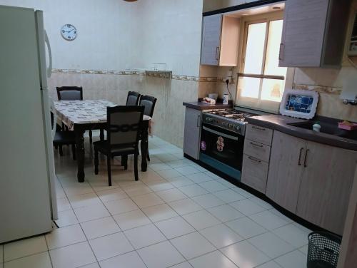 麦地那Soma Apt的厨房配有桌子、炉灶和桌椅