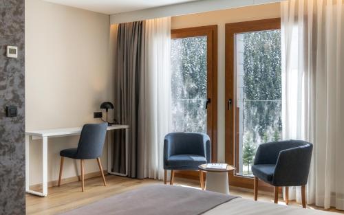 巴奎伊拉-贝莱特蒙塔图酒店的卧室配有两把椅子,窗户前设有一张桌子
