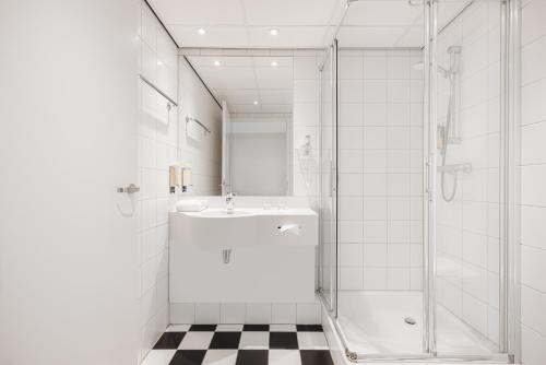 亨厄洛亨厄洛城市酒店的白色的浴室设有水槽和淋浴。