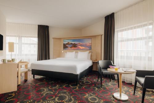 亨厄洛亨厄洛城市酒店的酒店客房带一张床、一张桌子和椅子