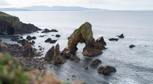 邓格洛Dungloe Lakeside Lodging的海滩上水中的一群岩石