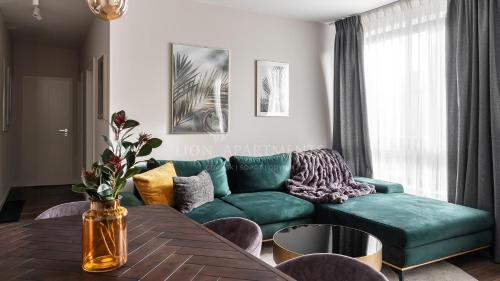 格但斯克Lion Apartments - SCALA City Center Apartments&Parking IK的客厅配有绿色沙发和桌子