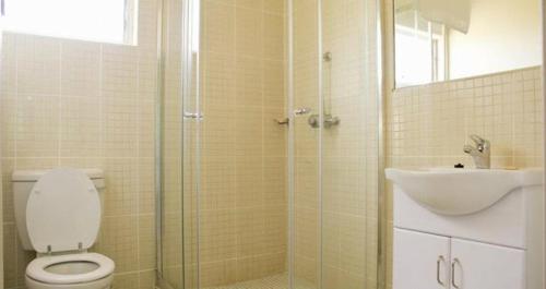 利文斯顿Victoria Apartments的带淋浴、卫生间和盥洗盆的浴室