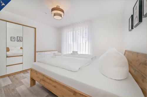 ZirchowAn der Haffküste Haffkoje的白色卧室配有床和镜子