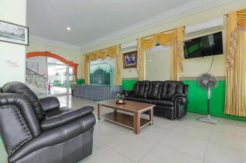 井里汶Permata Hijau的客厅配有皮革家具和平面电视