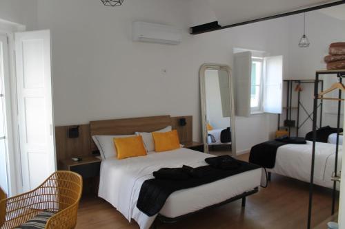 卡帕里卡海岸Real Guest House的一间卧室配有两张床和镜子