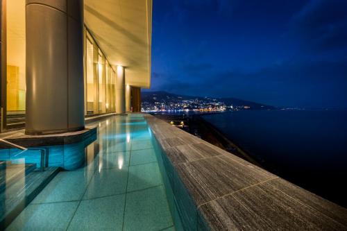 热海热海后乐园酒店(Atami Korakuen Hotel)的享有夜间水景的建筑