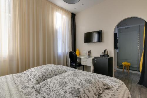 塔布亨利四世酒店的一间卧室配有一张床、一张书桌和一面镜子