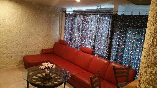 SzomolyaRiolit Barlangszállás Szomolya的客厅设有红色的沙发和窗户。