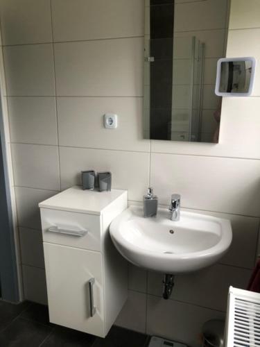 埃姆登Muuske的白色的浴室设有水槽和镜子